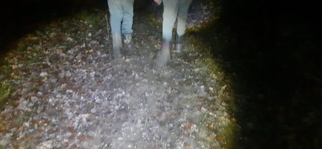 A terrible photo of two Scouts squelching through thick mud in the dark.